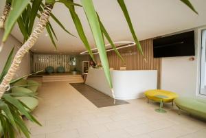 a lobby with green chairs and a white counter at Hotel Favorit in Venus