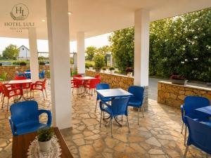 a patio with tables and chairs in a restaurant at Hotel LULI in Baks-Rrjoll