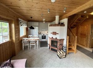 a kitchen and dining room with a fireplace in a cabin at Lumi-Ilves Iso-Syöte in Syöte