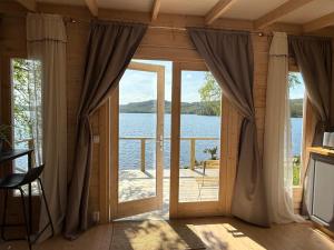 a room with a large glass door with a view of the water at Snibben Höga Kusten in Ramvik