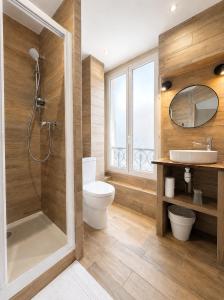 ein Badezimmer mit Dusche, Toilette und Waschbecken in der Unterkunft Angleterre Hotel in Paris