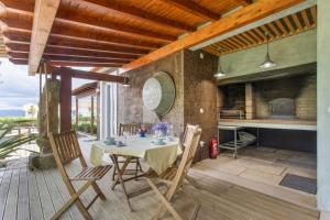 a dining room with a table and chairs on a patio at d'Olívia Lovely Homes in Cela