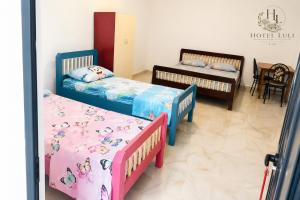 a room with three beds and a table and chairs at Hotel LULI in Baks-Rrjoll