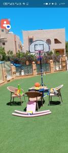 a playground with a wheel and chairs on the grass at Halfmoon House- fully air-conditioned- مكيف بالكامل in El Alamein