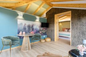 a room with a table and chairs and a bedroom at d'Olívia Lovely Homes in Cela