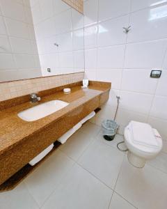 a bathroom with a sink and a toilet at Ubatuba Palace Hotel in Ubatuba