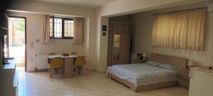 a bedroom with a bed and a table and a kitchen at AIRPORT 2 STOPS BY METRO FROM STUDIO & NEAR METRO station "PEANIA-KANTZΑ" in Leondárion +31 photos