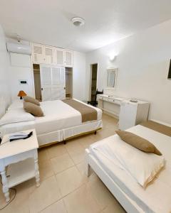 a hotel room with two beds and a kitchen at Ubatuba Palace Hotel in Ubatuba