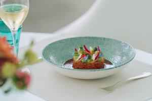 a bowl of dessert on a table with a glass of wine at Hotel Eden Roc Marina in Ascona +21 photos