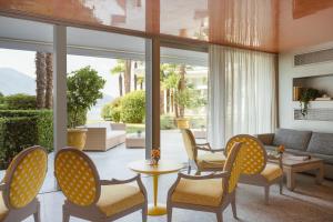 a living room with chairs and a couch and a table at Hotel Eden Roc Marina in Ascona