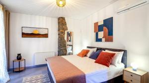 a bedroom with a bed with orange and blue pillows at Saronic Citadel Luxury Villa-Private Estate on Salamina Island in Salamina +73 photos