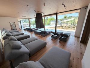 a living room with couches and tables and large windows at Landhotel Wratschko - Wirtshaus - Gamlitz - ehem Hotel am Marktplatz in Gamlitz