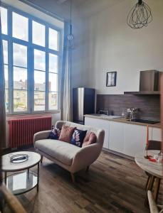 a living room with a couch and a kitchen at Le secret show in Saumur