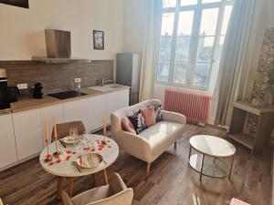 a living room with a couch and two tables at Le secret show in Saumur +23 photos