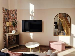 a living room with a flat screen tv on the wall at Le secret show in Saumur