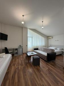 a large living room with a bed and a couch at Hotel Captain in Gonio