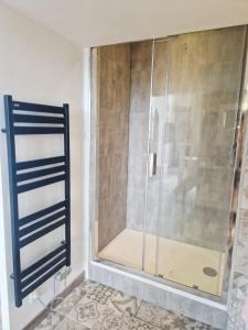 a shower with a glass door in a bathroom at Le secret show in Saumur