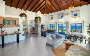 a living room with a vaulted ceiling and a stone fireplace at Saronic Citadel Luxury Villa-Private Estate on Salamina Island in Salamina
