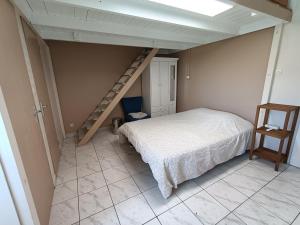 a small bedroom with a bed and a staircase at Chambre cosy in Saint-Paul