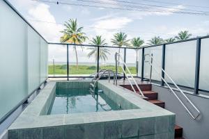 a swimming pool with a view of the ocean and palm trees at Sun Smart por Quarto a Vista in Ilha da Restinga