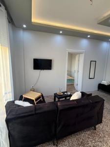 a living room with a couch and a flat screen tv at Cozy Central Home with Balcony in Alexandroupoli +2 photos