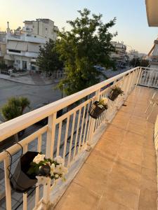 a balcony with potted plants on a white railing at Cozy Central Home with Balcony in Alexandroupoli