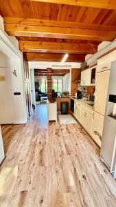 a large kitchen with wooden ceilings and wooden floors at Chalupa u rybníčku in Doksy