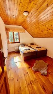 a bedroom with two beds and a wooden ceiling at Chalupa u rybníčku in Doksy