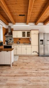 a kitchen with white cabinets and a wooden ceiling at Chalupa u rybníčku in Doksy