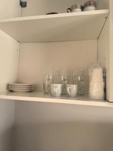 a shelf with cups and plates on it at Cozy Central Home with Balcony in Alexandroupoli