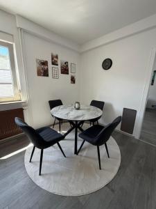 a dining room with a table and four chairs at Ferienwohnung Auszeit in Vöhl