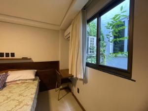 a bedroom with a bed and a large window at Hospedaria de Maria in Salvador
