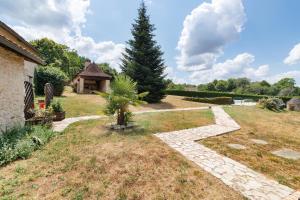 a garden with a tree and a gazebo at Gite xl proche Grottes Lascaux in Fossemagne