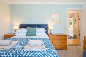 a bedroom with a blue and white bed with towels on it at Glandraeth in Newport