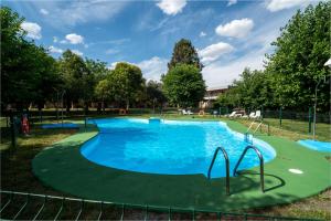 a large pool with blue water in a park at Hotel Los Olivos in Getafe