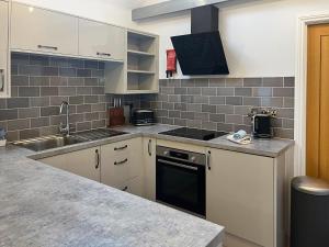 a kitchen with a sink and a stove top oven at The Barn - Uk50912 in Wansford