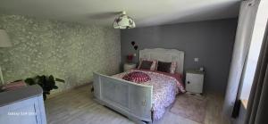 a bedroom with a bed with a white bed frame at La Maison Ôtrement in Martelange