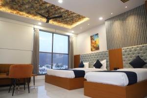 a hotel room with two beds and a window at Hotel Pride Of Chittor in Chittaurgarh