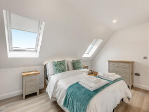 a white bedroom with a bed and a window at Fallow's Holt in Buildwas +10 photos