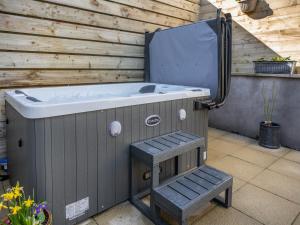 a jacuzzi tub sitting next to a wooden wall at The Old Byre in Edmondbyers