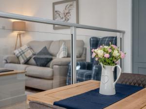 a vase of flowers on a table in a living room at The Old Byre in Edmondbyers