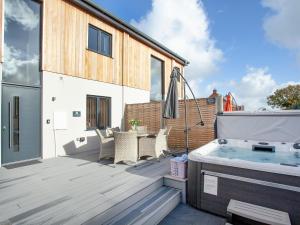 a deck with a hot tub on a house at Primrose-Uk34614 in Nether Stowey