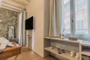 a room with a bed and a tv and a window at La Corte del Lario - Contrada Vecchia in Varenna