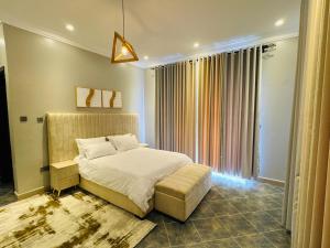 a bedroom with a bed and a large window at Bellwether Apartments in Kampala +36 photos