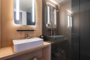 a bathroom with a white sink and a mirror at ibis Issoire in Issoire