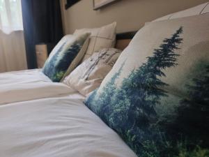two pillows on a bed with a pine tree on them at Borovets Gardens Studio Raya in Borovets