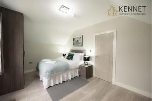 a bedroom with a white bed and a nightstand at Laurel House in Reading