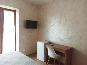 a bedroom with a bed and a desk and a television at Pimpus in Cicciano