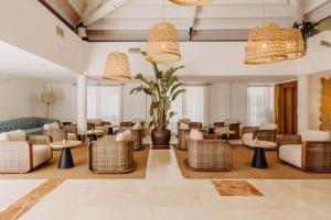 a hotel lobby with tables and chairs and chandeliers at Lago Resort Menorca - Casas del Lago Adults Only in Cala en Bosc
