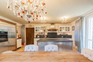a kitchen with a dining table and a chandelier at Luxury Villa in Tremezzo con piscina in Tremezzo